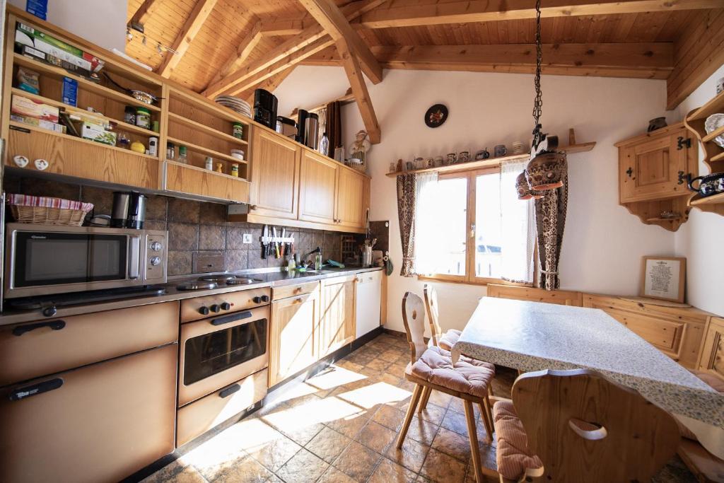 a kitchen with wooden cabinets and a table at Ferienhaus Alvaneu für Familien in Alvaneu