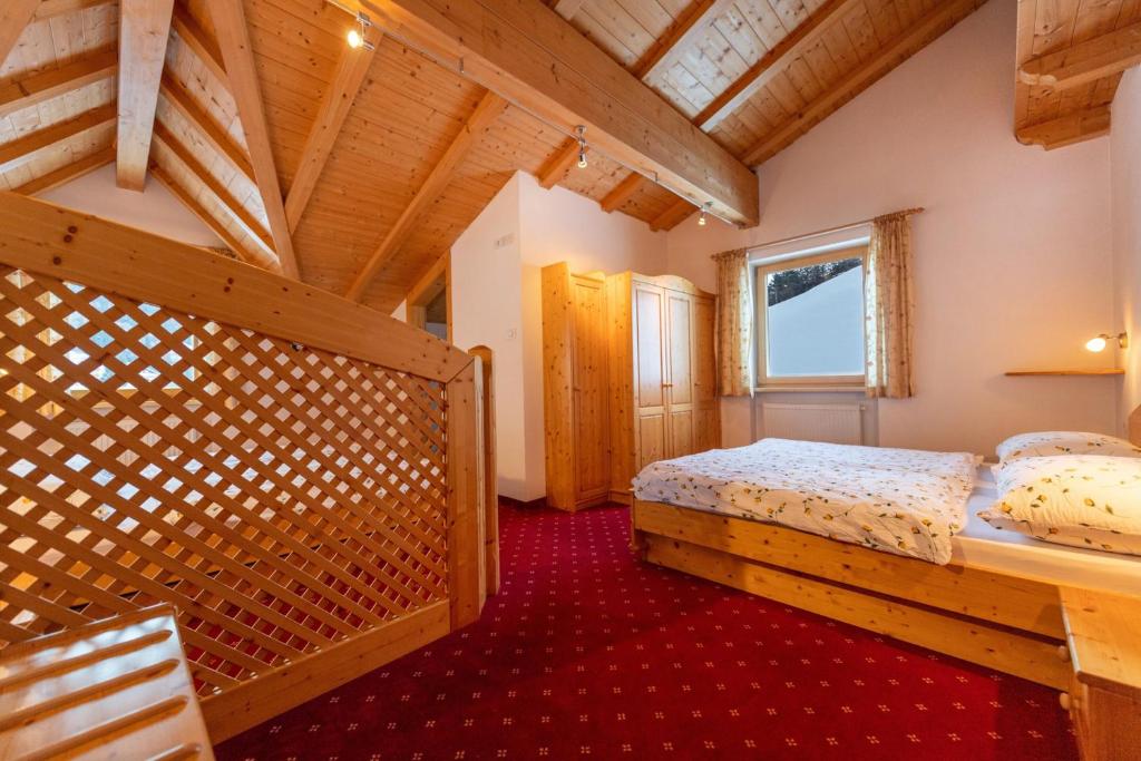 una camera con 2 letti e un soffitto in legno di Apartments Agave a Ortisei