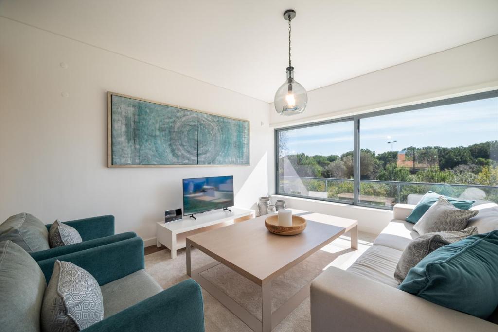 una sala de estar con un sofá y una mesa en Apart L'Orange, en Vilamoura