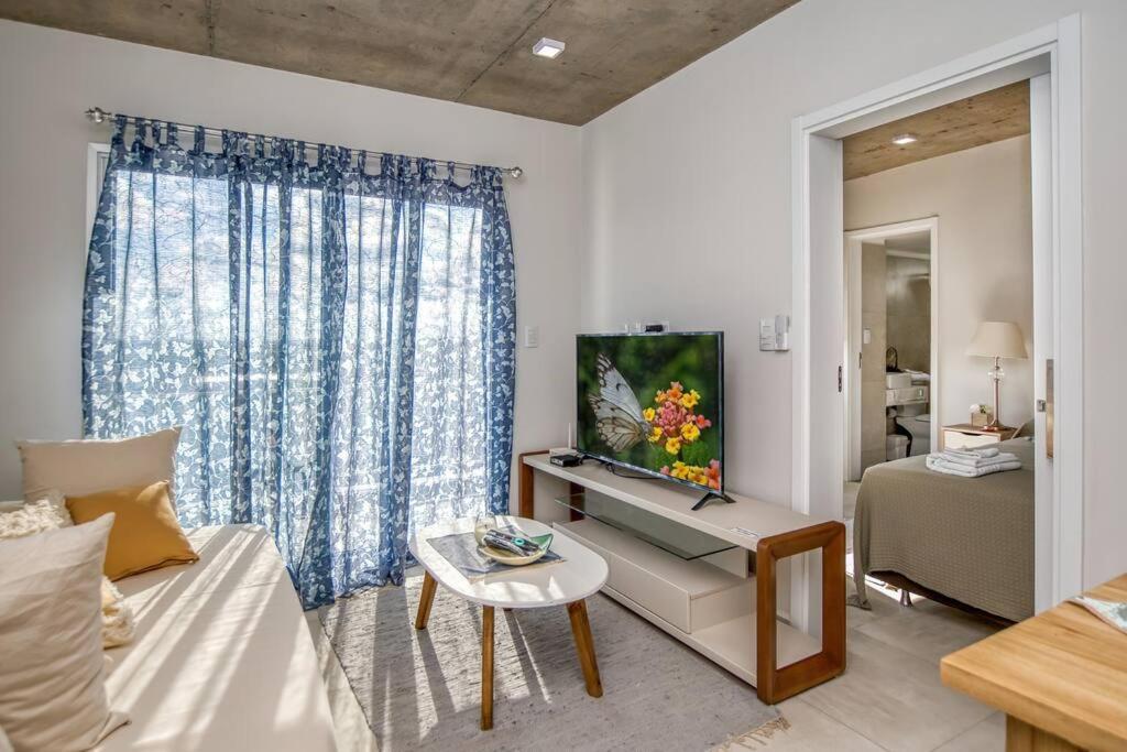a living room with a couch and a tv at A estrenar! Apartamento con pileta zona aeropuerto WIFI 200MG in La Mercedes