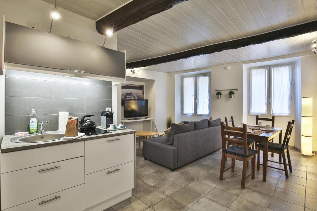une cuisine et un salon avec une table et un canapé dans l'établissement Jolie 2 pièces quartier Bonaparte/ Clim, à Nice