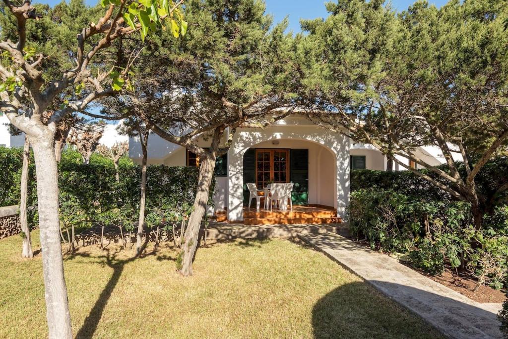a house with trees in front of a yard at Brisa Mar 1, 2 bedroom apartment, Cala'n Bosch in Son Xoriguer