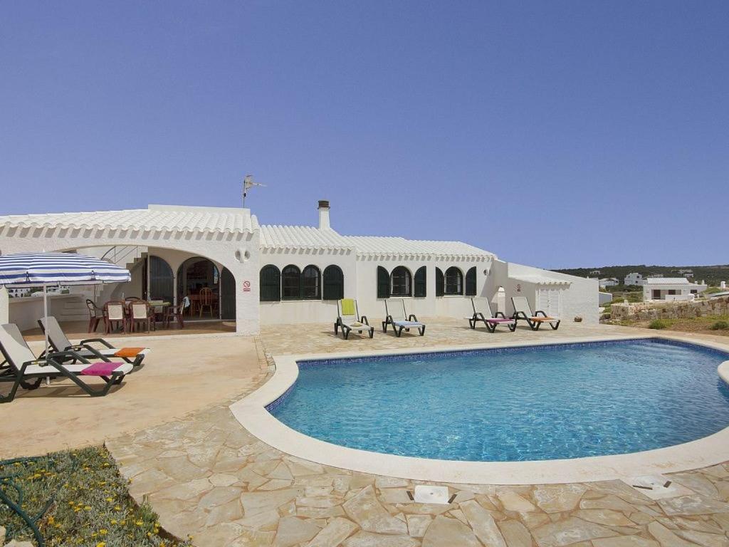 una casa con una piscina di fronte di Villa Lira a Cala Morell