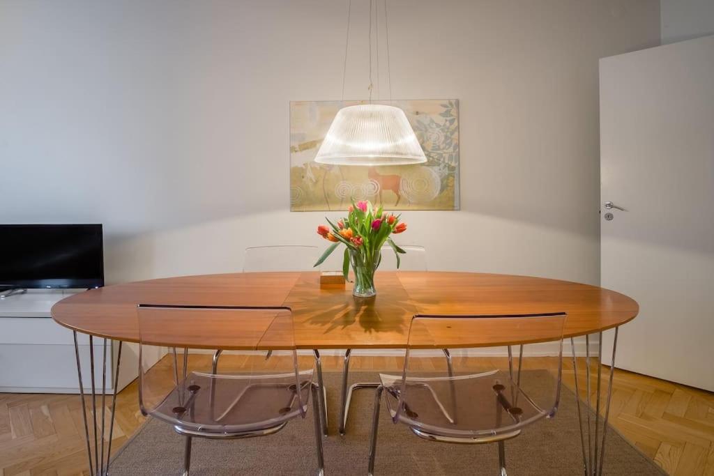 uma mesa de jantar com um vaso de flores em Stockholm Checkin Apartment Alvik em Estocolmo