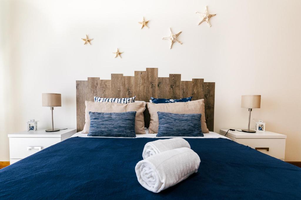 ein Schlafzimmer mit einem großen blauen Bett mit zwei Kissen in der Unterkunft Baleal Beachfront Apartment in Ferrel