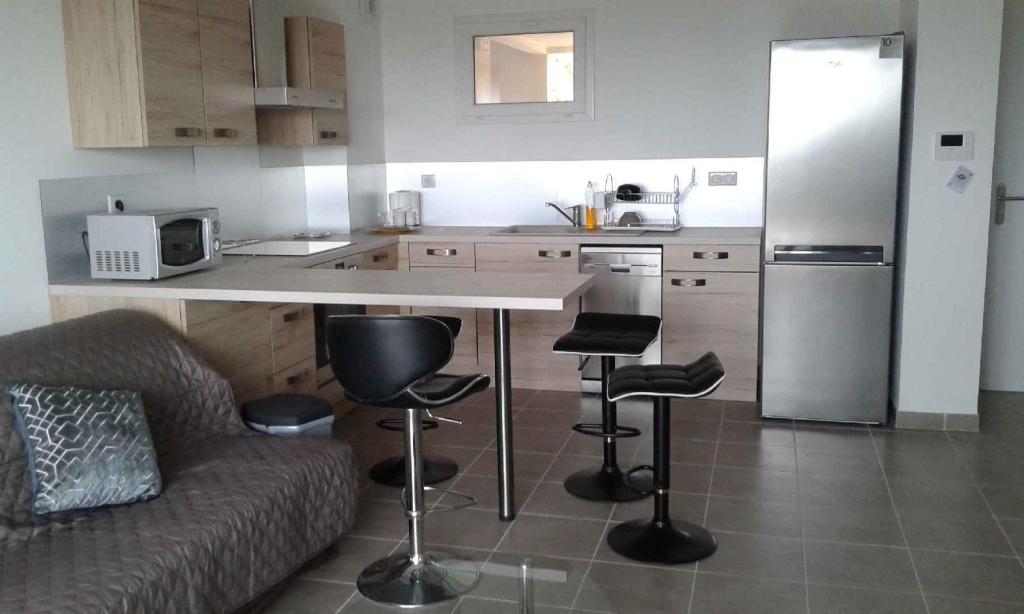 a kitchen with a couch and a counter with stools at Bella Vista 2A in Ajaccio