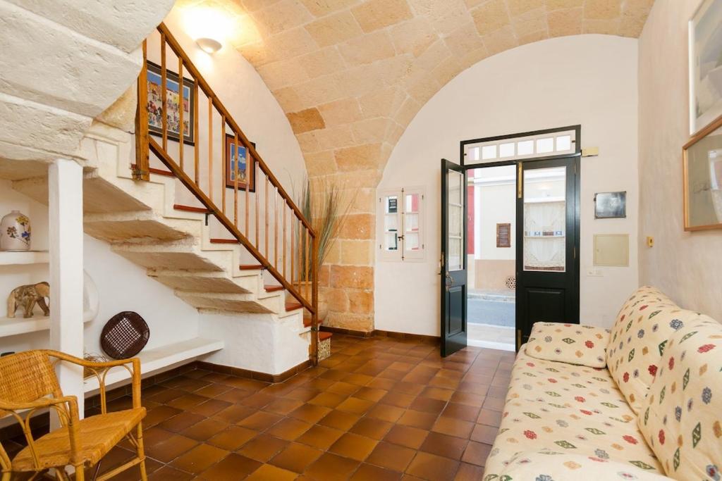 a living room with a couch and a staircase at SA FONT in Ciutadella