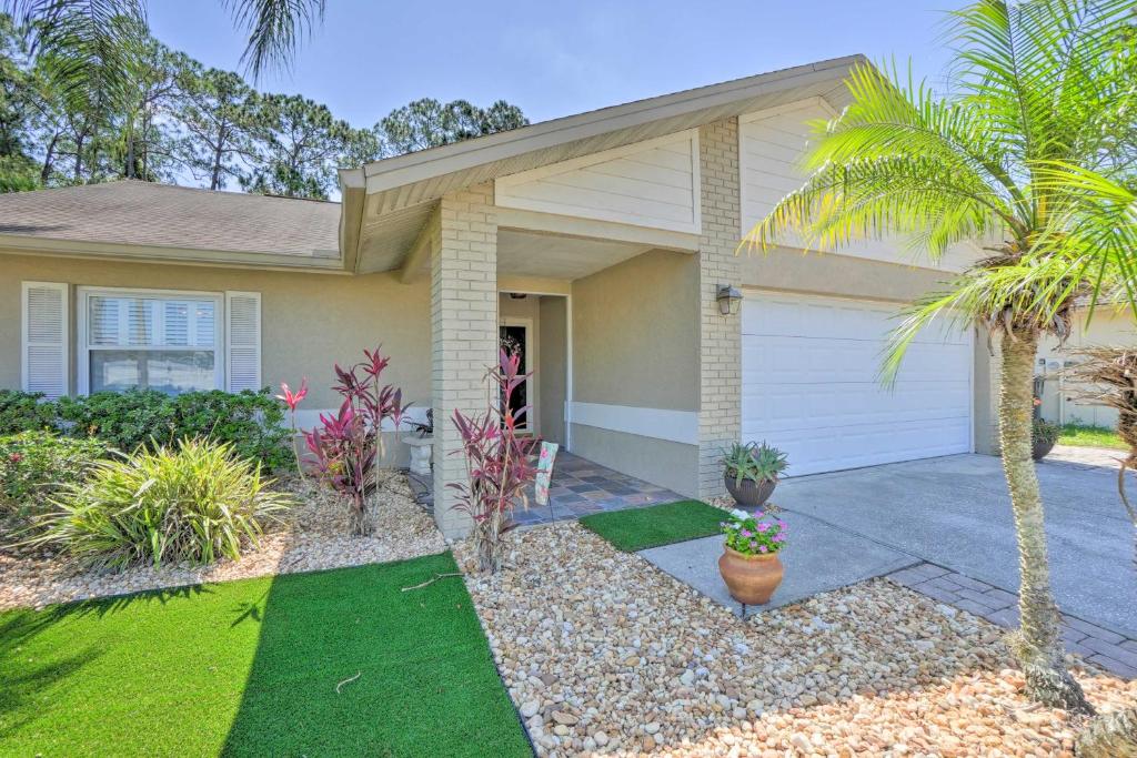 a house with a palm tree in front of it at Tampa Home with Hot Tub about 15 Mi to Downtown! in Tampa