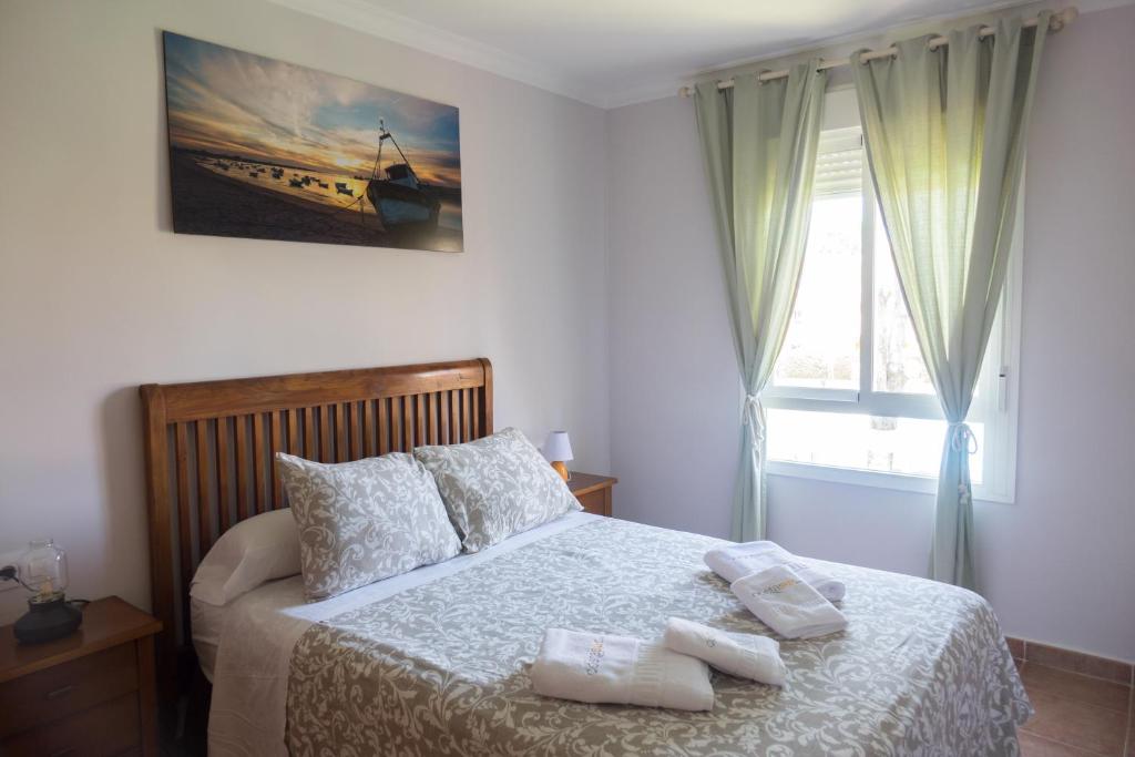 a bedroom with a bed with two towels on it at Apartamento Jardin del Golf in Novo Sancti Petri