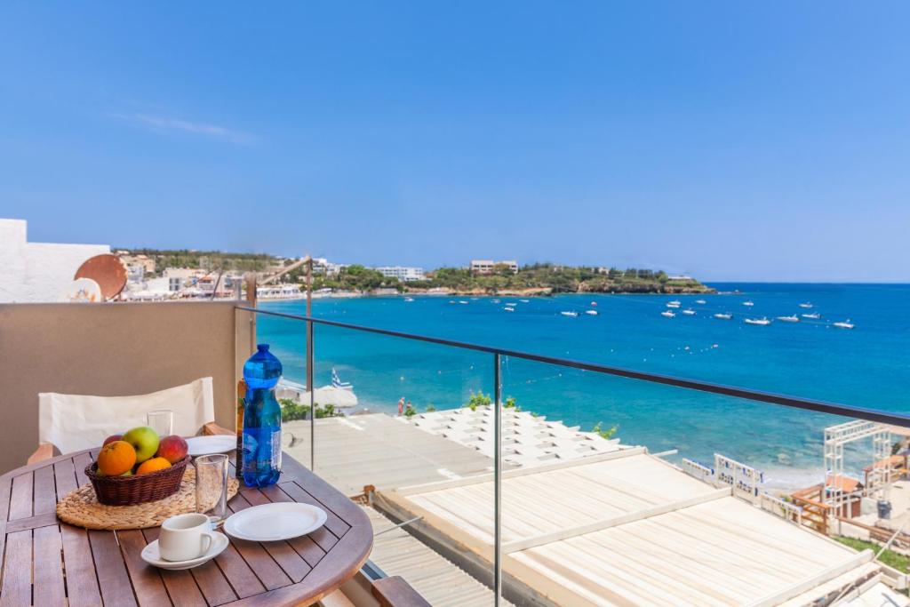 een tafel op een balkon met uitzicht op de oceaan bij Michalis Apartments in Agia Pelagia