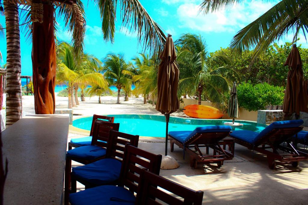 a pool with chairs and umbrellas next to a resort at Egina Luxury Villa in Uaymitun