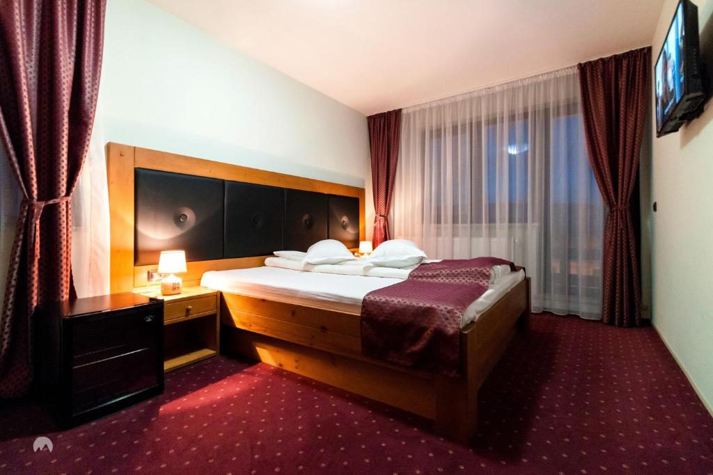 una camera d'albergo con letto e finestra di White House a Făgăraş