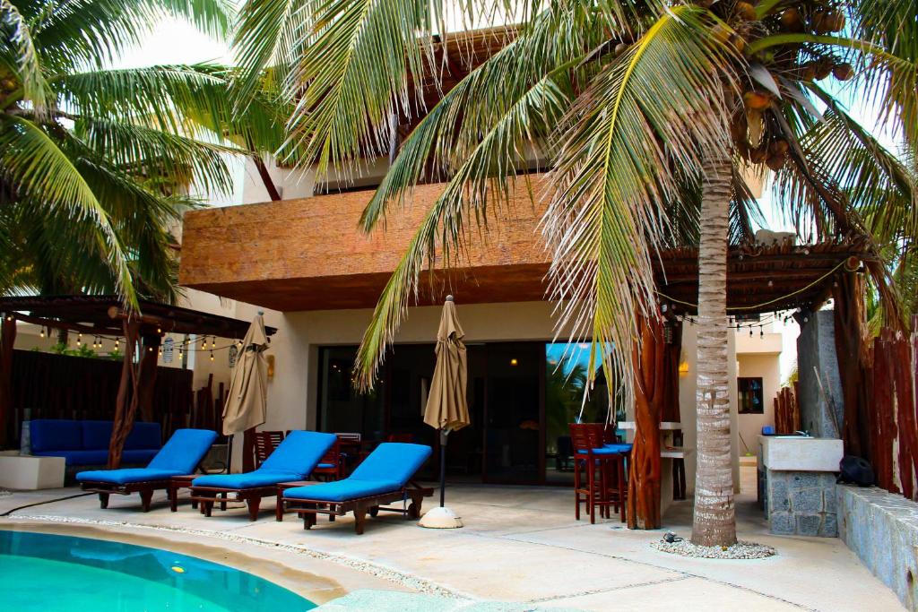 a resort with a pool and chairs and a palm tree at Egina Luxury Villa in Uaymitun