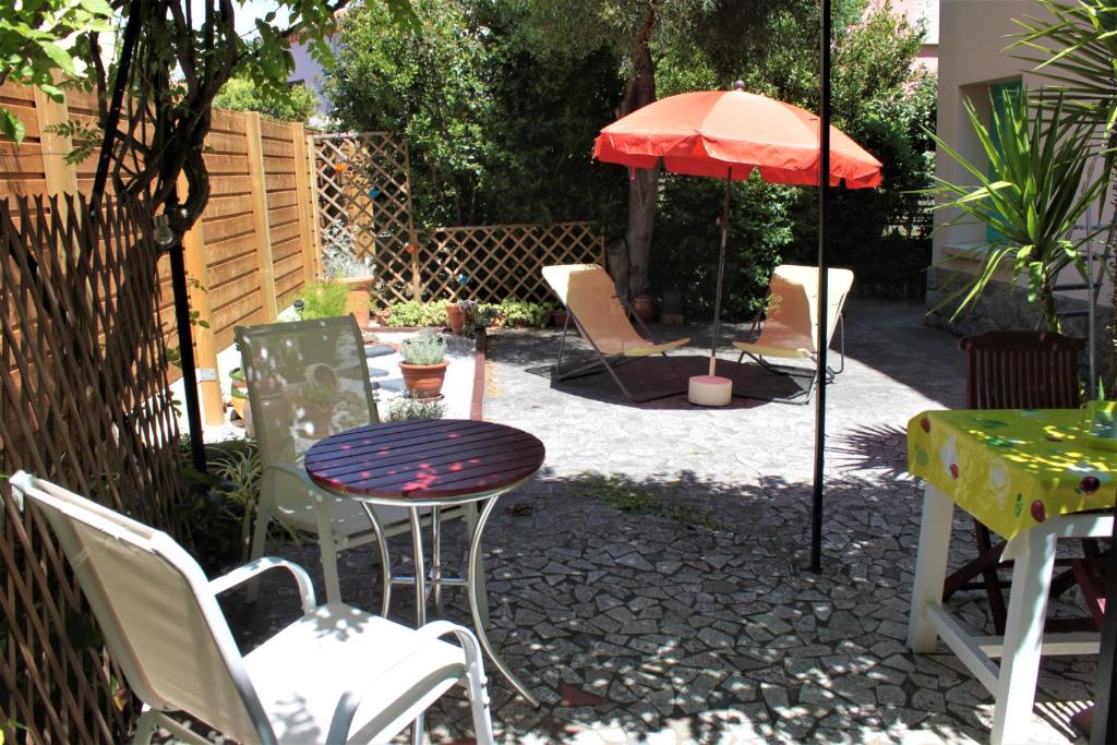 eine Terrasse mit einem Tisch, Stühlen und einem Sonnenschirm in der Unterkunft Ta Maria in Céret