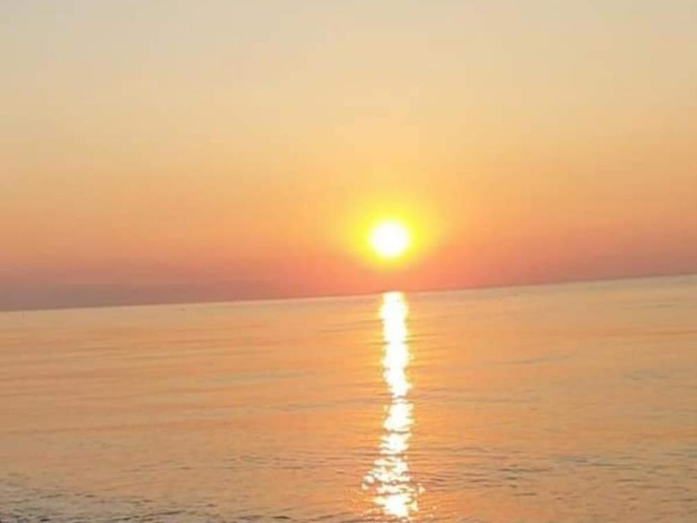 un tramonto sull'oceano con il sole che riflette nell'acqua di Appartamento Tramonto Rosso a Catania