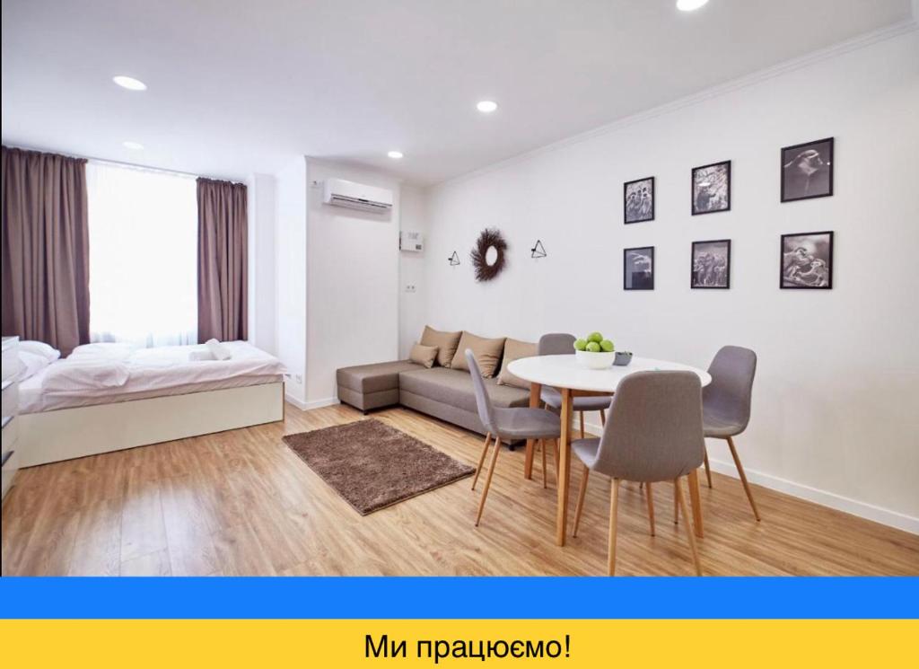 salon z łóżkiem, stołem i krzesłami w obiekcie Nordian w Charkowie