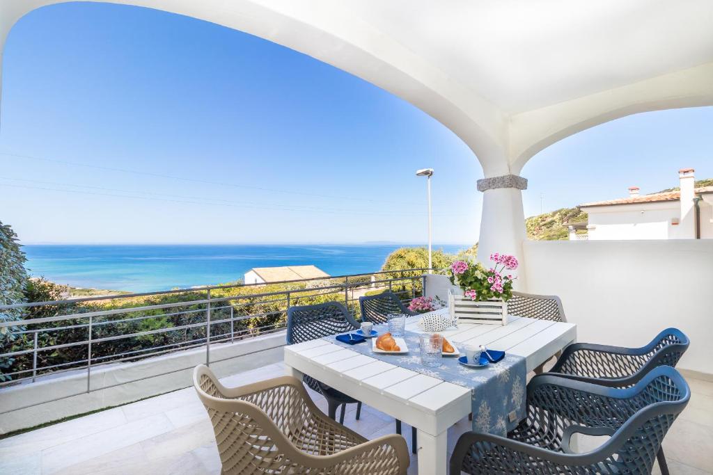 a white table and chairs on a balcony with the ocean at Residence L'Olivastro in Castelsardo