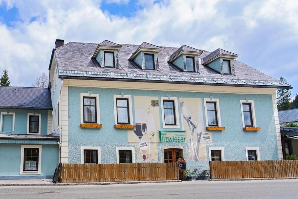 a blue house with a fence in front of it at Gasthof Filzwieser in Mitterbach