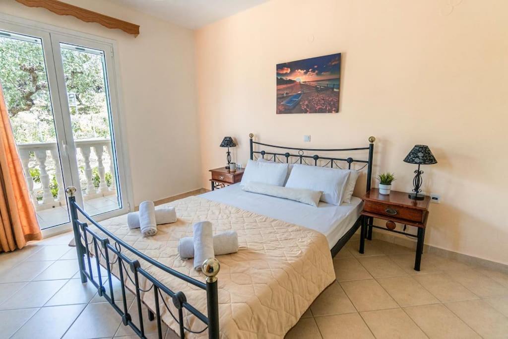 a bedroom with a bed and a desk and a window at Sunny Aprt at Klelia Cottage in Zakynthos Town