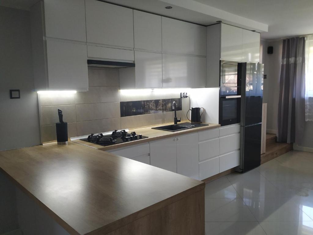 a kitchen with white cabinets and a counter top at APARTAMENT OSTROWO 1 in Ostrowo