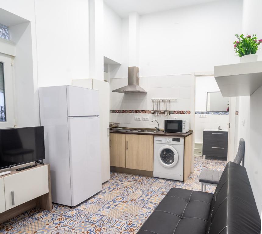 cocina con sofá y cocina con lavadora en Precioso loft en el corazón de triana, en Sevilla