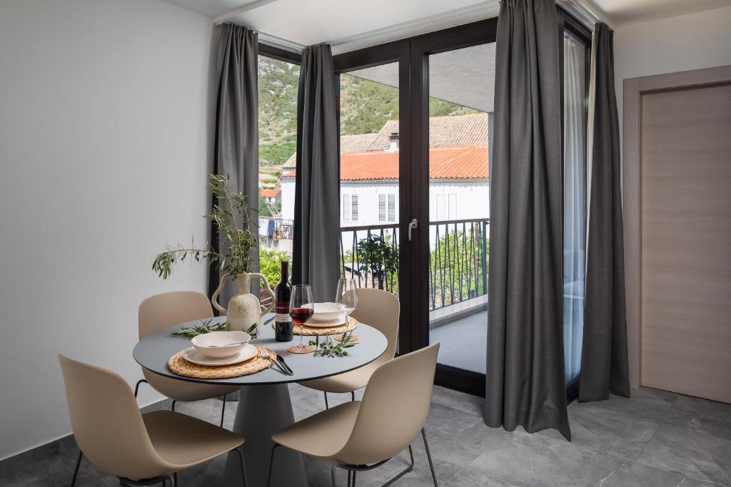 a dining room with a table and chairs and a window at Residence THE ONE - new in Komiža