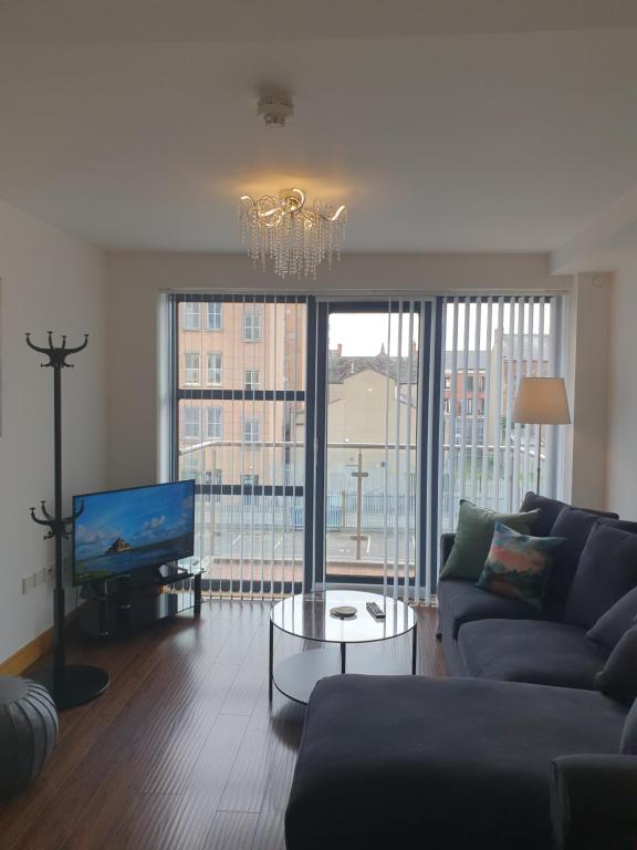 a living room with a couch and a flat screen tv at VICTORIA PLACE in Belfast