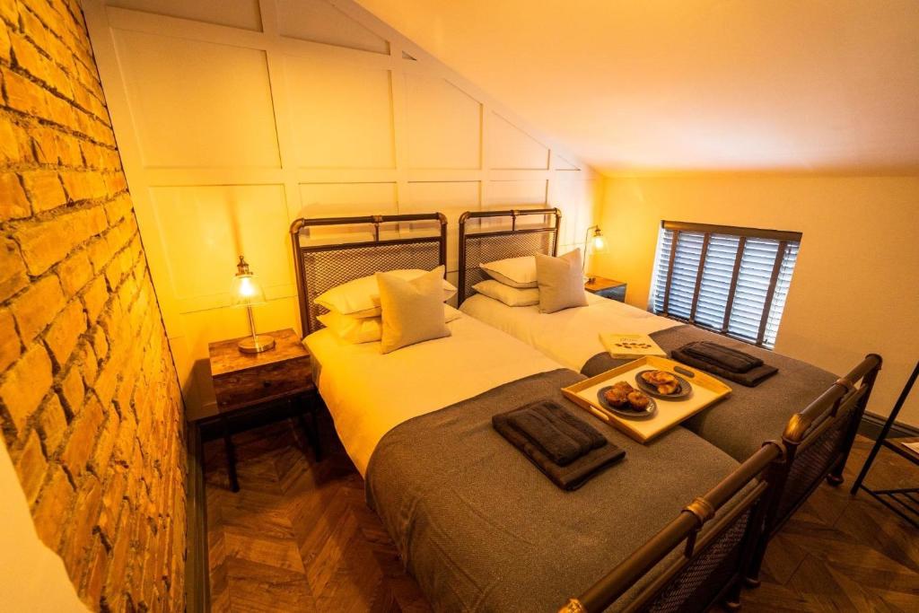 a bedroom with two beds with a tray of food at Town center cottage with Hot tub in Morpeth