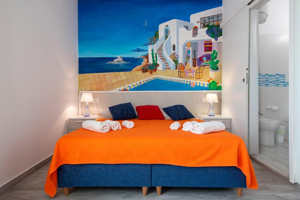a bedroom with a large orange bed with towels on it at B&B La Terrazza Sul Porto in San Foca