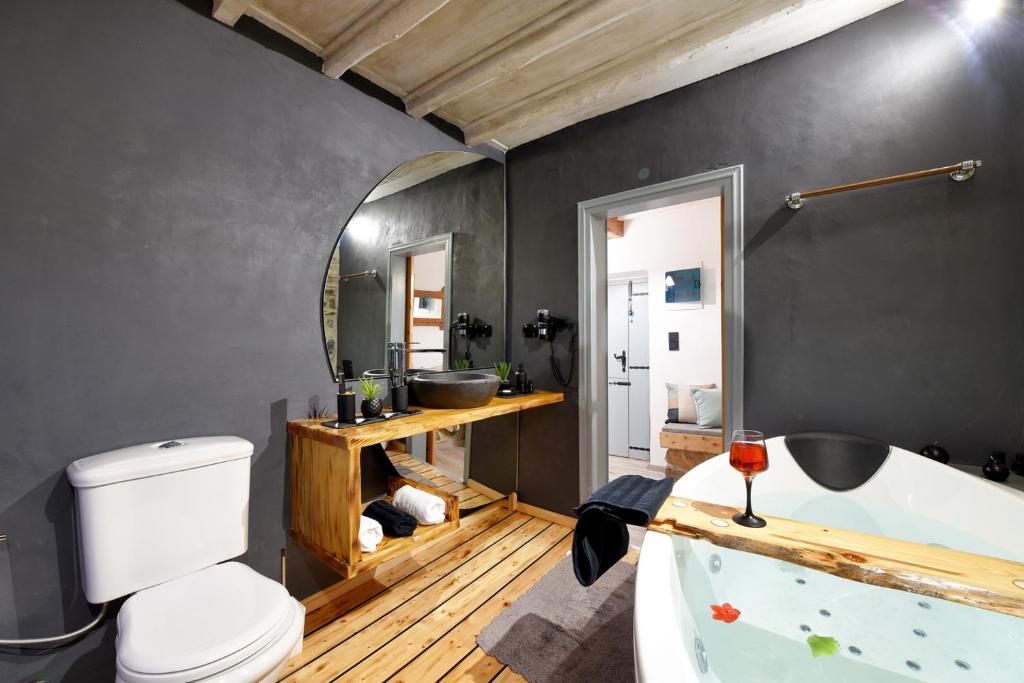 a bathroom with a white tub and a toilet at Tramuntana in Ano Syros