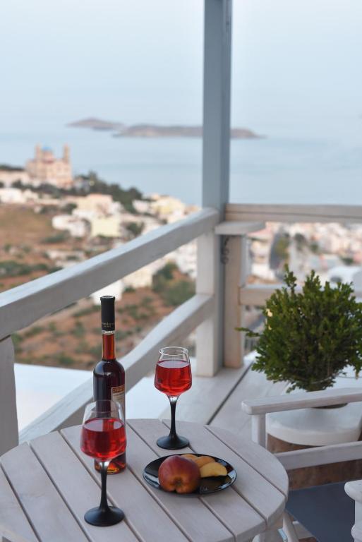 a table with two glasses of wine and a plate of fruit at Tramuntana in Ano Syros