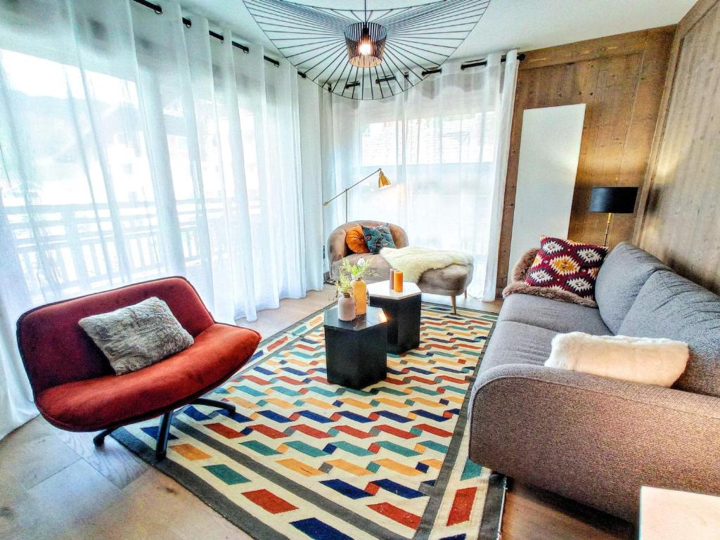 ein Wohnzimmer mit einem Sofa und Stühlen auf einem Teppich in der Unterkunft Appartement Les Gets, 4 pièces, 6 personnes - FR-1-598-78 in Les Gets