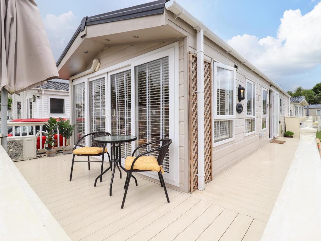 a deck with a table and chairs on a house at 9 Birch Grove in Clacton-on-Sea
