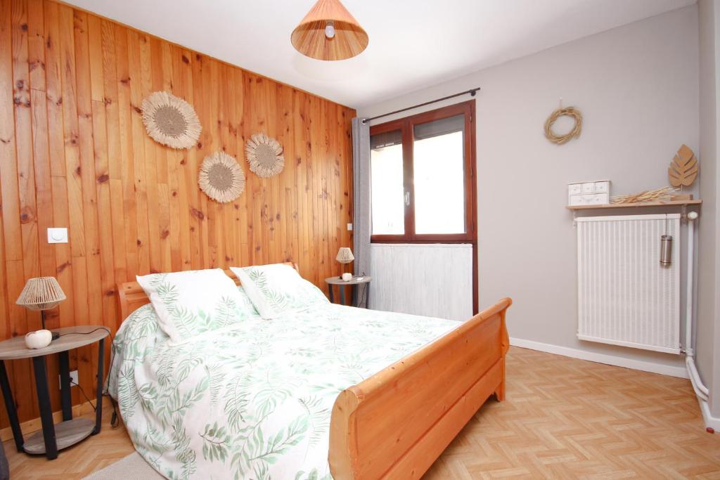 - une chambre avec un lit et un mur en bois dans l'établissement Coquet appartement Type 2 de 56 m² en centre ville, à Briançon