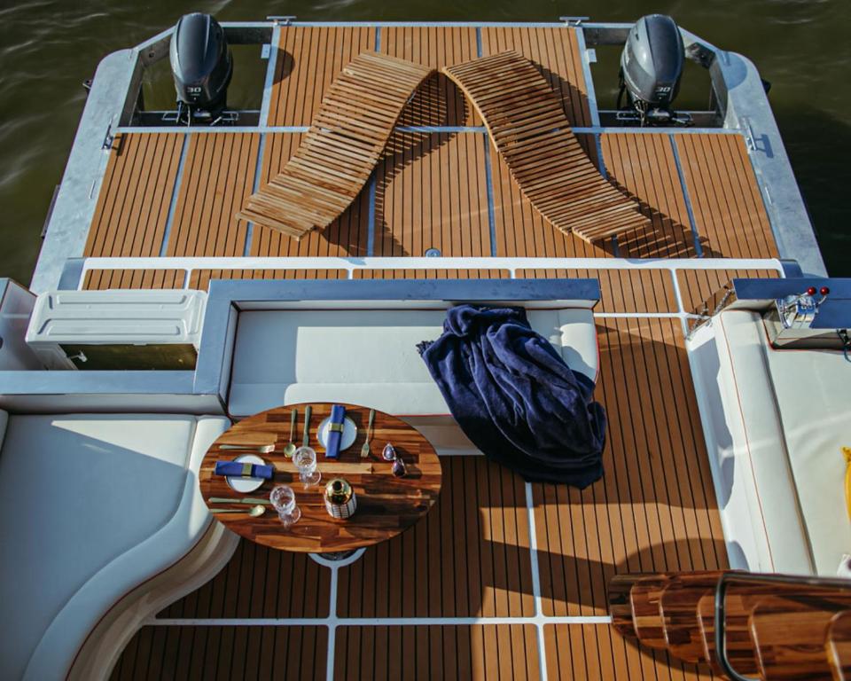 a wooden deck on a boat in the water at Hausboot mit Traumlage in Lübeck-Travemünde in Rönnau