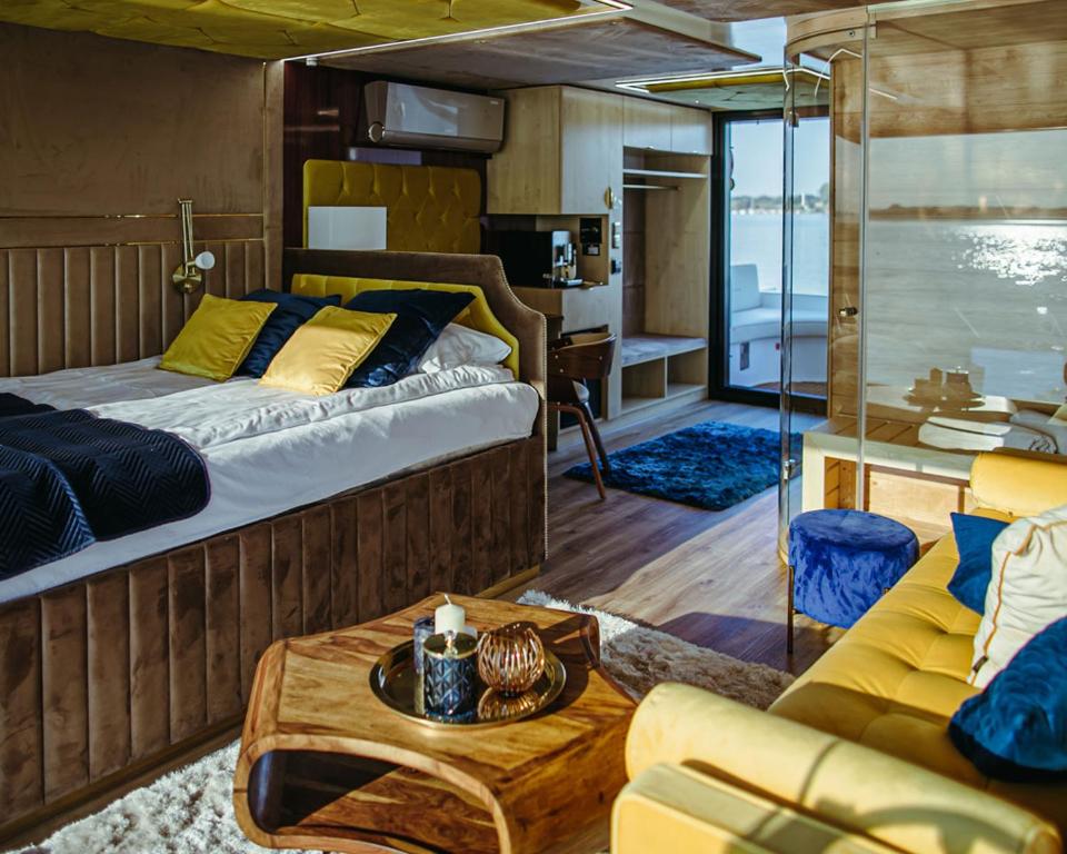 a bedroom with a bed and a couch and a table at Hausboot mit Traumlage in Lübeck-Travemünde in Rönnau