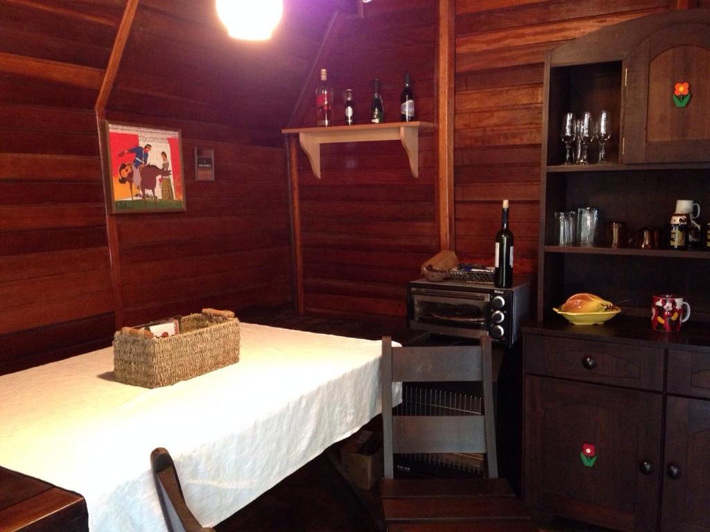 a kitchen with a table and a stove in it at Cabana dos Alpes in Canela