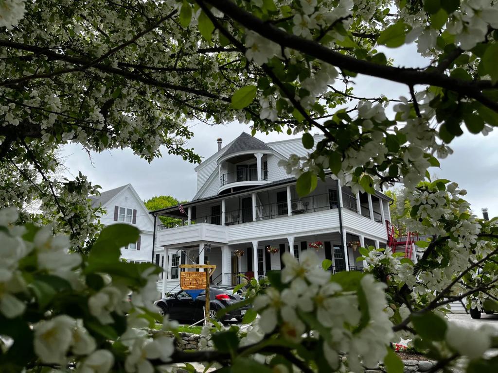 a white house with white flowers in the foreground at Queen Anne's Revenge in Bar Harbor