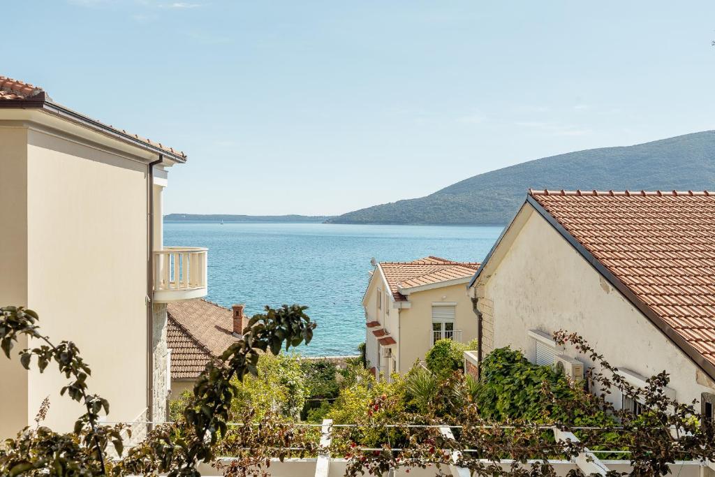 widok na ocean pomiędzy budynkami w obiekcie Apartmani Divna w mieście Herceg Novi