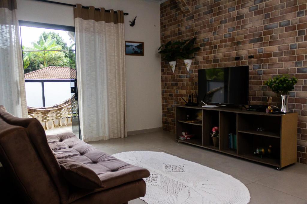 a living room with a couch and a television at Aconchego Premium in Angra dos Reis
