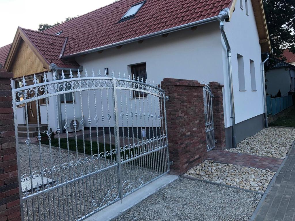 una puerta de metal frente a una casa en Fazekas Vendégház en Balatonkeresztúr