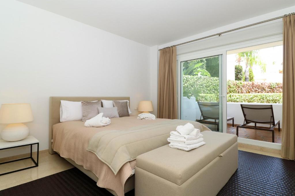 sypialnia z dużym łóżkiem i balkonem w obiekcie Family apartment with garden- Los Monteros Palm Beach w Marbelli