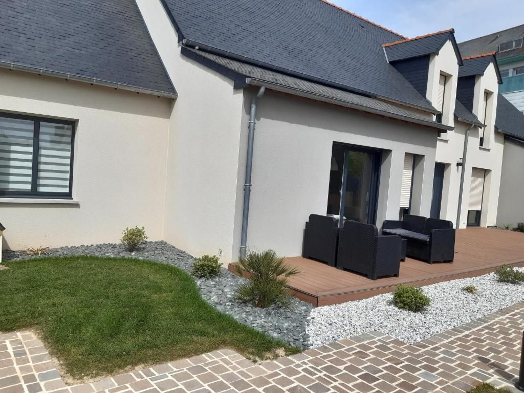 uma casa com um deque com duas cadeiras pretas em Cœur de ville, chambre confortable à louer en Bretagne em Saint-Méen-le-Grand