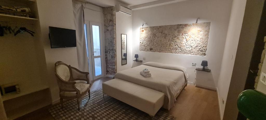 a bedroom with a bed and a chair and a window at Beni Benius in Cagliari