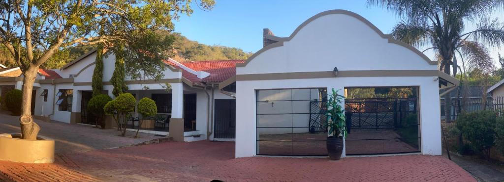 a white building with a potted plant in it at A Pousada Guesthouse in Nelspruit