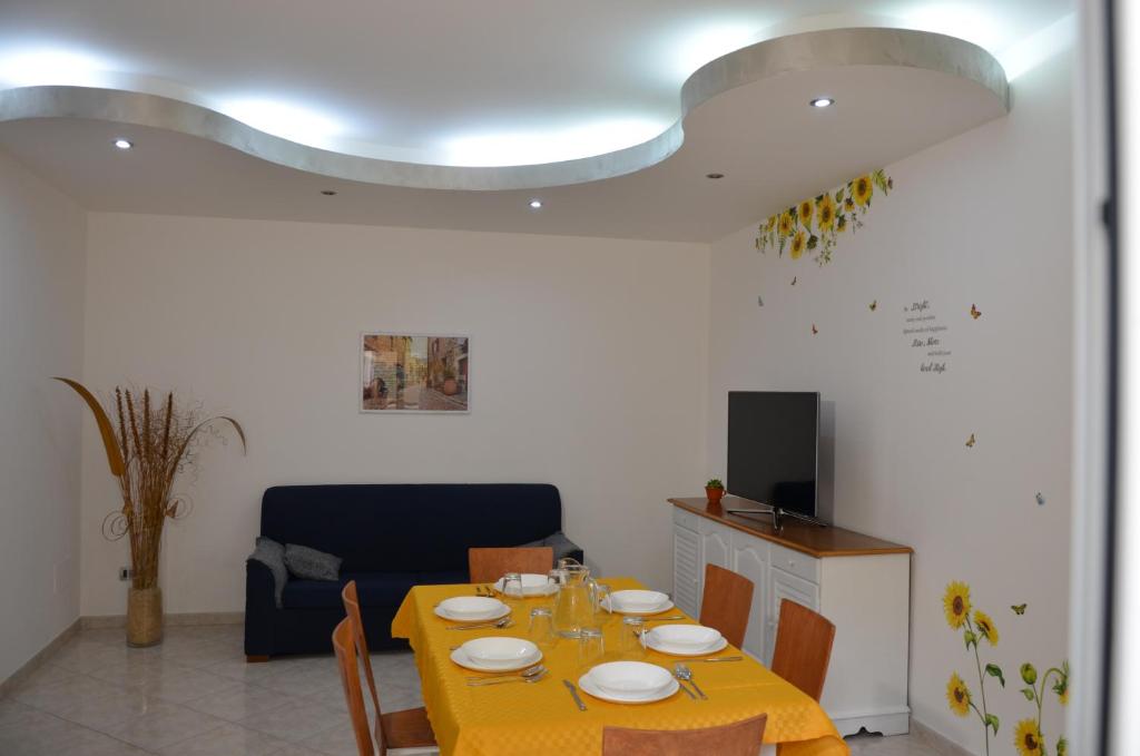 a dining room with a yellow table and chairs at Il Girasole del Centro Storico in Alcamo