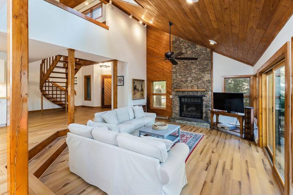 a living room with a white couch and a fireplace at 7th Hole Chalet at Wintergreen Resort Hot Tub, Sauna & 3 Fireplaces in Wintergreen