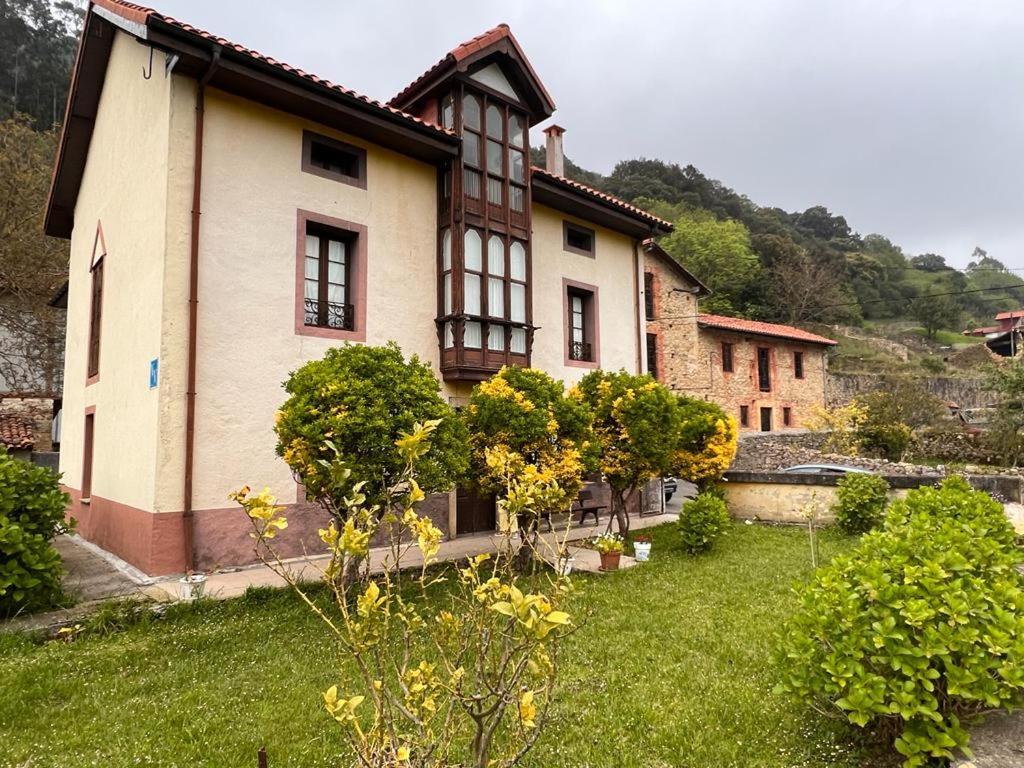 Buelles的住宿－Villa Milera，前面有一座绿色庭院的房子