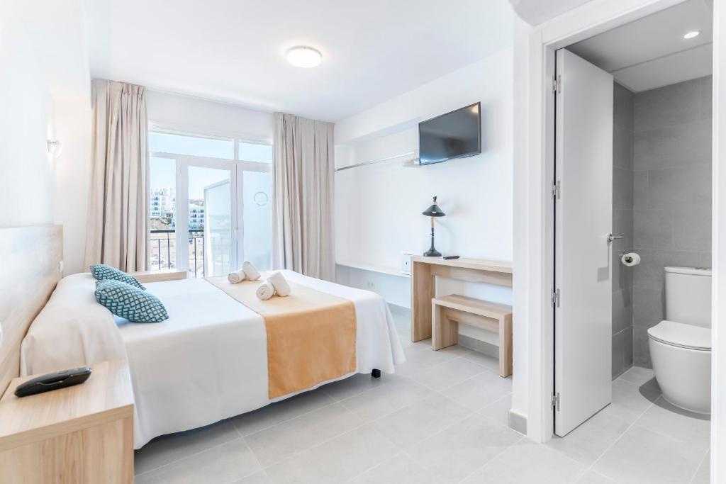a hotel room with a bed and a bathroom at Suncoast Ibiza Hotel - Adults Only - in Ibiza Town