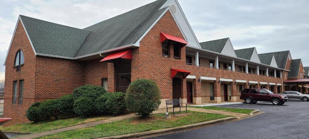 a red brick building with a black roof at Red Roof Inn & Suites Cornelius - Lake Norman in Cornelius